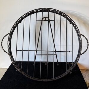 Round dule black, wrought iron stand and tray. It has a folding easel-style back